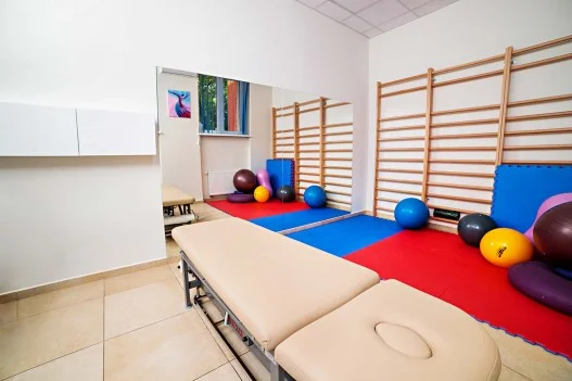Gabinet fizjoterapii Łódź, wyposażenie to łóżko fizjoterapeutyczne, piłki do ćwiczeń, drabinki