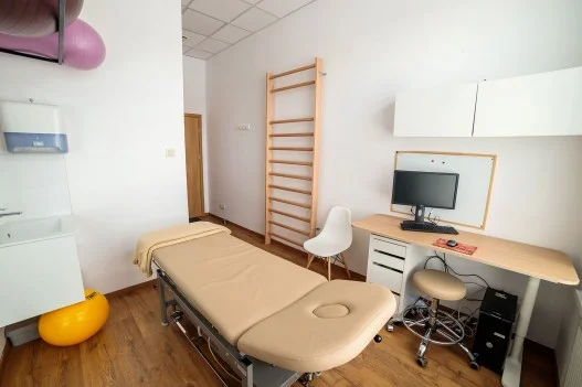 Gabinet fizjoterapii pediatryczne w Łodzi, łóżko elektryczne,  piłki rehabilitacyjne dywan, biurko komputer, klimatyzacja